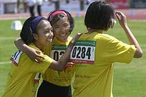 Three female athletes share a victory hug at the 2003 World Summer Games in Ireland