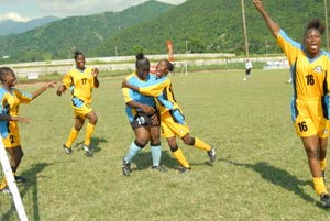 Members of the female football team from SO Bahamas rush in for hugs after a victory