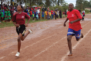 Despite the rain, a small crowd turns out in Rwanda to watch two women athletes race down the track